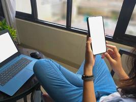 computer, leerer bildschirm telefonmodellbild mit weißem hintergrund für werbung, frauenhand mit laptop und handy auf dem tisch im cafe.mockup foto