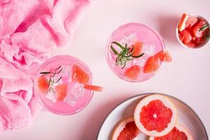 Rosa Cocktail mit Rosmarin in Gläsern auf dem Tisch. rosa lebensmittelkonzept. Ansicht von oben foto