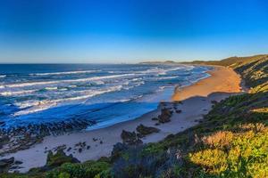 Blick auf den Strand von Brenton in Südafrika bei Sonnenaufgang foto