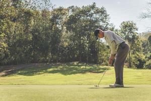 Mann spielt Golf auf einem Golfplatz. foto