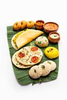 südindisches masala dosa, uttapam, idli vada sambar, grieß halwa, upma serviert auf bananenblatt foto