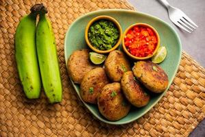 rohes Bananenschnitzel, auch Wegerich oder kacche kele ki tikki oder Patties genannt, serviert mit Chutney foto