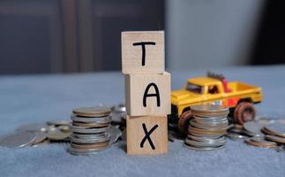 Konzept der Steuern für Autos auf Blockwürfeln, die von Einzelpersonen und Unternehmen gezahlt werden, wie z. B. Mehrwertsteuer, Einkommensteuer und Grundsteuerdatenanalyse, Papierkram, Finanzforschung. foto