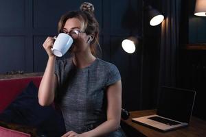 Schöne Geschäftsfrau, die spät in der Nacht in ihrem Büro arbeitet foto