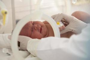 ein neugeborenes baby liegt in boxen im krankenhaus. ein Kind in einem Inkubator. Neugeborenen- und Frühgeborenen-Intensivstation foto
