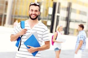 glücklicher student, der auf dem campus steht foto