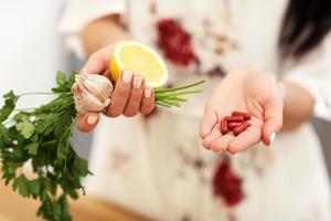 junge frau, die medizin und zitronen-knoblauch-petersilie hält foto