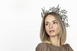 eine junge frau mit blonden haaren mit einem weihnachtskranz. neujahrskonzept, weihnachtsschmuck. foto