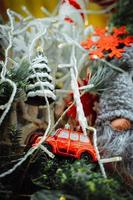 rotes auto, schneeflocke und weihnachtsbaum auf kiefernzweigen foto