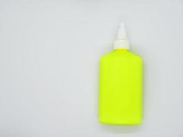 eine hellgrüne Flasche Kleber auf weißem Hintergrund. schöne Rohrnahaufnahme. grüne Plastikflasche. foto
