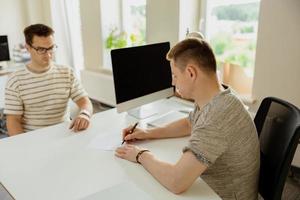 seriöser professioneller mann, der kunden im büro berät. zwei männer treffen sich, führen geschäftsgespräche. versicherer berät, manager macht angebot. Mentor Lehrpraktikant Vorstellungsgespräch. foto