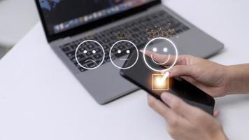 Kundenservice-Bewertungskonzept. Die Verwendung eines Smartphones drückt ein zufrieden lächelndes Gesicht Emoticon auf einem virtuellen Touchscreen. foto