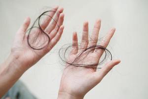 asiatische frau hat ein problem mit langem haarausfall in der hand. foto