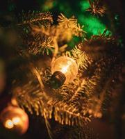 gelbes weihnachtslicht, das in einem weihnachtsbaum hängt foto