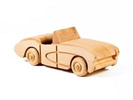 Foto des Cabriolets eines Retro-Autos aus Buche. Spielzeug aus Holz auf einem weißen, isolierten Hintergrund