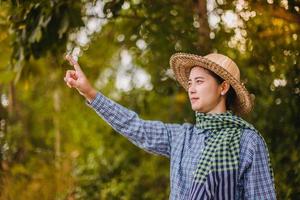 junge Frau, die auf etwas auf einem weißen Hintergrund zeigt foto