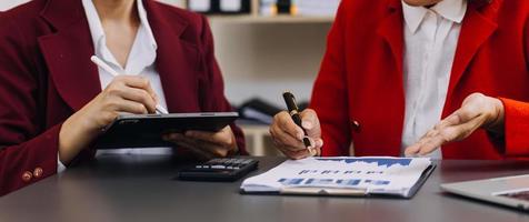 Geschäftsteam anwesend. Foto professioneller Investor, der an einem neuen Startup-Projekt arbeitet. Finanzmeeting.digitales Tablet-Laptop-Computer-Smartphone mit Tastatur-Docking-Bildschirm Vordergrund, Filter