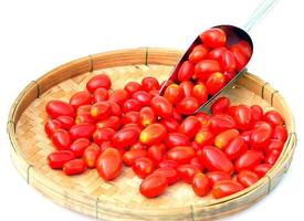 frische rote reife Tomaten in Bambuskörben auf weißem Hintergrund. weicher und selektiver Fokus foto