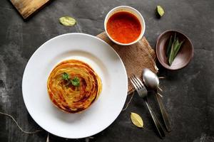 Paratha-Brot oder Canai-Brot oder Roti Maryam, beliebtes Frühstücksgericht. auf Teller serviert foto