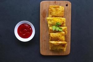 frittierte risole oder risol mayo sind indonesische snacks. wie coxinha de galinha. serviert mit Chilisauce, Sellerie auf Holzplatte foto