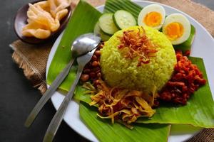 nasi kuning oder gelber reis oder kurkumareis ist ein traditionelles essen aus asien, hergestellter reis gekocht mit kurkuma, kokosmilch r foto