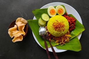 nasi kuning oder gelber reis oder kurkumareis ist ein traditionelles essen aus asien, hergestellter reis gekocht mit kurkuma, kokosmilch r foto