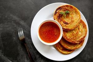 Paratha-Brot oder Canai-Brot oder Roti Maryam, beliebtes Frühstücksgericht. auf Teller serviert foto