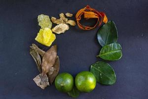 Wedang Uwuh ist ein traditionelles Kräutergetränk aus Indonesien. aus Zimt, Muskatnuss und Nelkenblättern. eine weitere zutat ist holz vom secangbaum, ingwer und würfelzucker auf schwarzem hintergrund foto