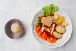 Selat Solo ist ein traditionelles Salatgericht aus Indonesien. aus hart gekochten Eiern, gekochten Kichererbsen, gekochten Karotten, Rösti und Salat, Steak oder Bistik. auf Holztisch serviert foto