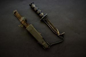 Dunkelschwarzes Militärmesser auf schwarzem Hintergrund foto