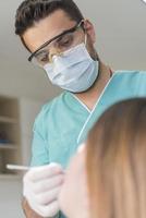 Zahnarzt heilt die Zähne des Patienten und füllt den Hohlraum. zahnarzt, der mit professioneller ausrüstung in der klinik arbeitet. foto