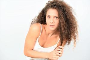 Frau mit unordentlichem lockigem Haar auf weißem Hintergrund foto