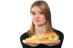 Porträt eines schönen lustigen jungen Mädchens, das Hamburger isst. foto