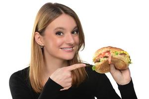 Porträt eines schönen lustigen jungen Mädchens, das Hamburger isst. foto