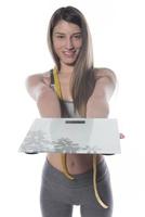 weibliches Modell mit Waage und Maßband auf weißem Hintergrund foto