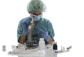 wissenschaftler in blauen medizinischen handschuhen und einheitlichen lernenden covid-19-proben mit mikroskop im labor. foto