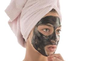 schwarze Gesichtsmaske. schönes Mädchen mit schwarzer Kosmetikmaske im Gesicht. Beauty-Konzept foto