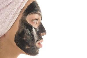 schwarze Gesichtsmaske. schönes Mädchen, das schwarze Maske ablegt. Beauty-Konzept foto