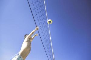 Kind spielt Volleyball an einem schönen Sommertag foto