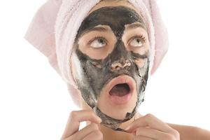 schwarze Gesichtsmaske. schönes Mädchen, das schwarze Maske ablegt. Beauty-Konzept foto