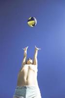 Kind spielt Volleyball an einem schönen Sommertag foto