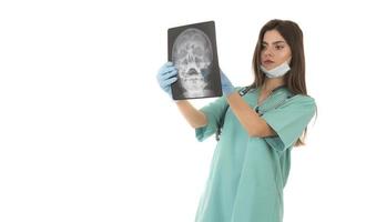 junge ärztin, die sich das röntgenbild ansieht. isoliert auf weiß foto