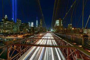 new york city manhattan downtown skyline bei nacht von der brooklyn bridge mit dem tribute in light zur erinnerung an den 11. september. foto