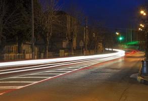 Autolichtspuren vom Bewegen eines Fahrzeugs in der Abenddämmerung in der Stadt foto