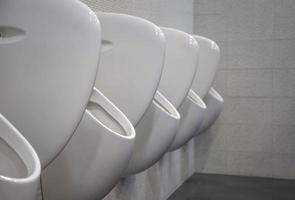 Closeup weiße Urinale im Herrenbad, das Design von weißen Keramik-Urinalen für Männer im Toilettenraum. öffentliche Herrentoilette, WC. foto