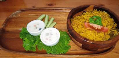 Reis-Lamm-Biryani-Pilaw mit Lammfleisch und Gemüsegurke dazu Joghurt foto