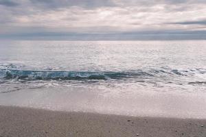 die küstenlinie des meeres am abend, wellen am strand, meer und himmel. foto