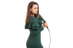 hübsche Frau im grünen Farbkleid mit Mikrofon foto