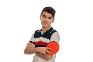 Schöner Sportler, der eine Tischtennisplatte mit Schläger in den Händen übt und die Kamera isoliert auf weißem Hintergrund betrachtet foto