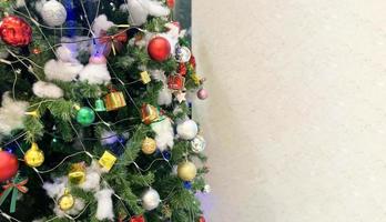 geschmückter Weihnachtsbaum mit bunten Geschenkbox und Glocke isoliert auf weißem Hintergrund foto